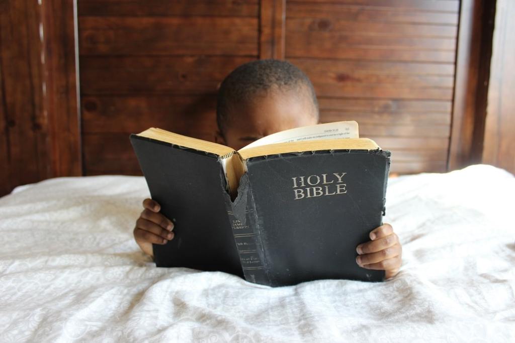Small boy reading the Bible